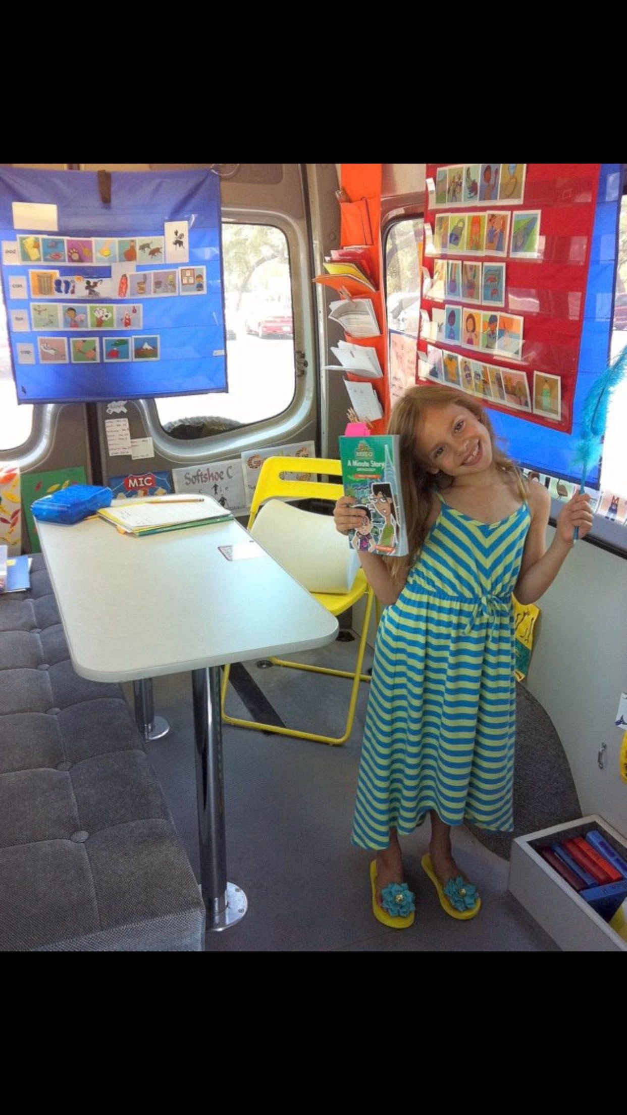 Girl inside mobile classroom holding a book